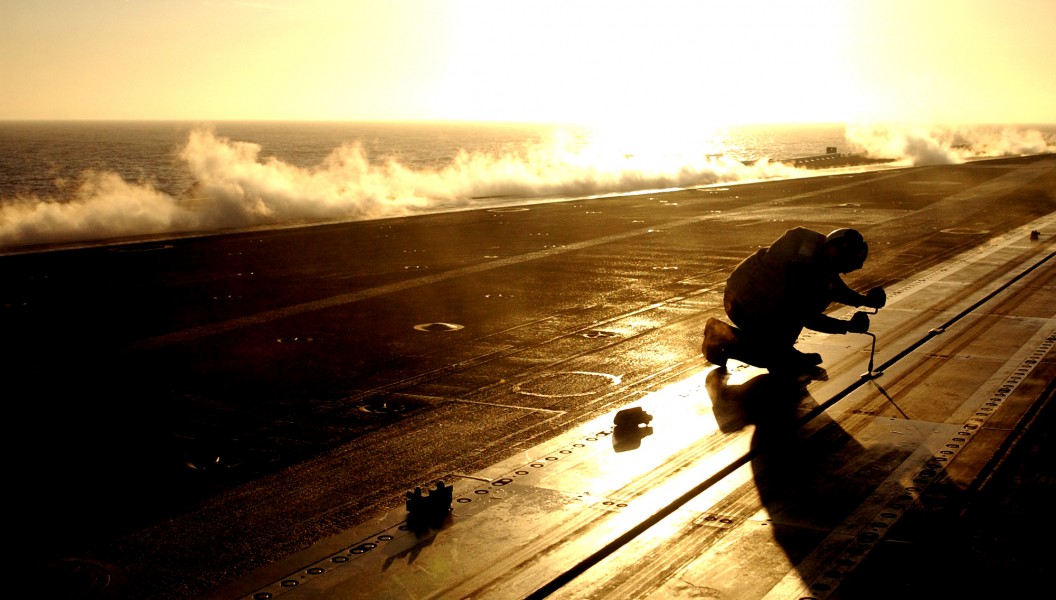 US Navy 030814-N-7732W-218 An Aviation Boatswain's Mate installs slot seals into the shuttle track of a steam catapult between flight operations aboard USS John C. Stennis (CVN 74)