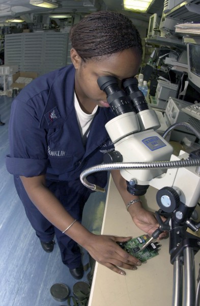US Navy 031014-N-2143T-003 Electronics Technician 3rd Class Ebony Franklin from Durham, N.C., solders a faulty circuit card 
