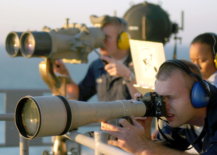 US Navy 031122-N-9742R-004 Photographer's Mate Airman William Howell photographs a merchant vessel