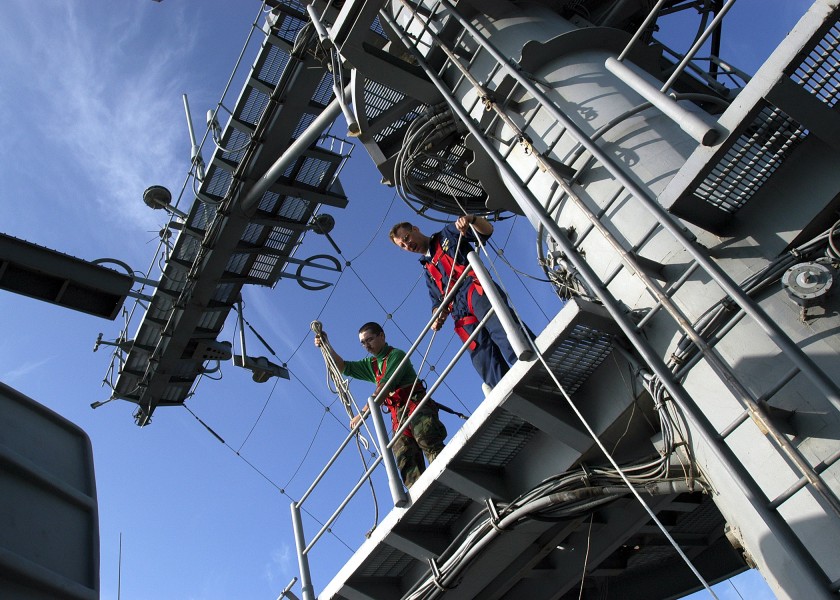 US Navy 040105-N-6187M-004 High above the flight deck aboard USS Enterprise (CVN 65), Chief Electrician's Mate David E. Zelinski from Toms River, N.J. prepares to lowers a tool bag 