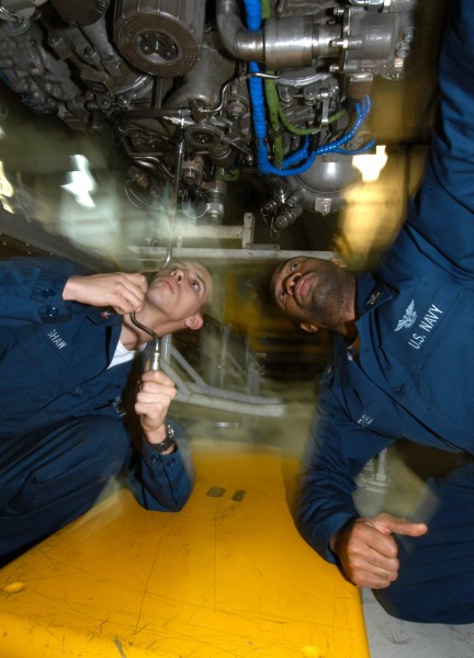 US Navy 040227-N-4190W-001 Aviation Machinist's Mates install a drain on an F-A-18C Hornet engine in the Jet Shop aboard USS John F. Kennedy (CV 67)