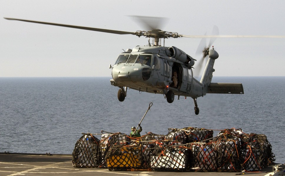 US Navy 040326-N-5319A-003 A crewmember assigned to USNS Sirius (T-AFS 8) attaches a cargo sling to a MH-60S Knighthawk