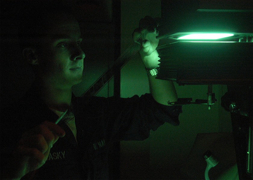 US Navy 040413-N-1522S-008 Photographer's Mate Airman Jason R. Zalasky, of Lake Hopatcong, N.J., views film negatives in a photographic darkroom aboard USS George Washington (CVN 73)