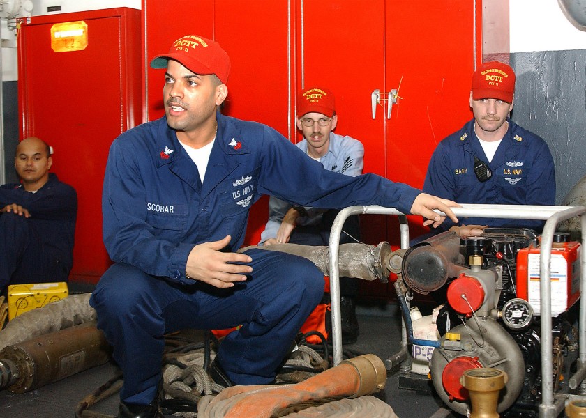 US Navy 040527-N-1045B-050 Damage Controlman 1st Class George Escobar, of Bronx, N.Y., trains Damage Control Training Team (DCTT) members on a P-100 pump