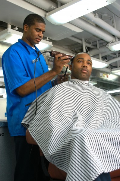 US Navy 040618-N-7569S-002 Ship Serviceman 3rd Class Derrick Davis cuts Ship Serviceman 3rd Class Frank Joyner^rsquo,s hair aboard the aircraft carrier USS John F. Kennedy (CV 67)
