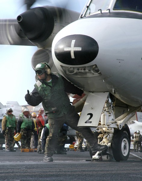 US Navy 040628-N-0119G-019 Aviation Boatswain's Mate 3rd Class David Reyes guides an E-2C Hawkeye on to one of four steam-powered catapults on the flight deck aboard USS Enterprise (CVN 65)