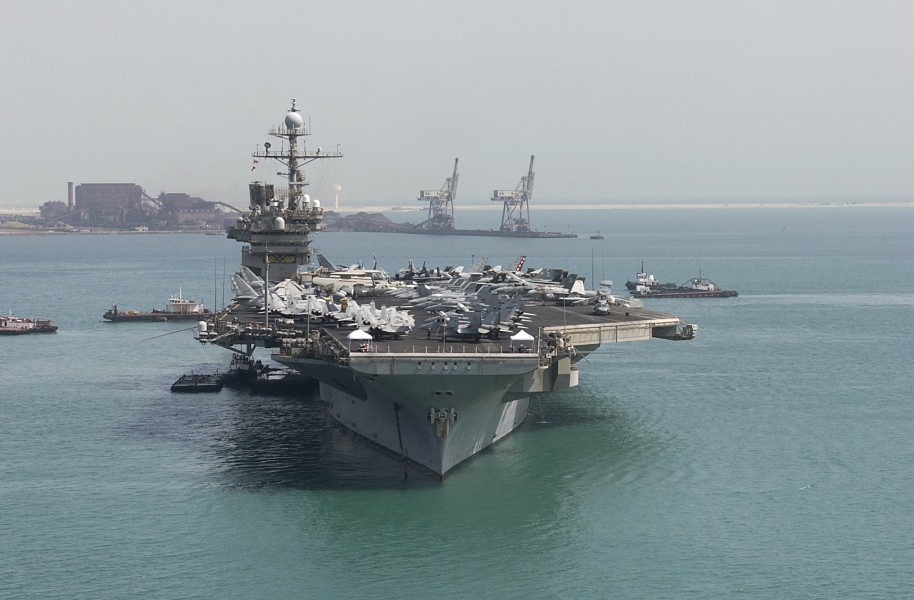 US Navy 040810-N-1348L-003 Tug boats and barges stand by as the aircraft carrier USS John F. Kennedy (CV 67) prepares to get underway after a five-day port visit to Bahrain