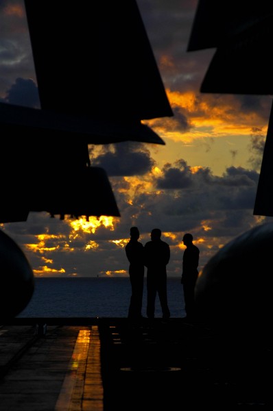 US Navy 041023-N-4166B-041 Pilots aboard the aircraft carrier USS Abraham Lincoln (CVN 72), assemble on the bow of the ship as the sunsets on the western Pacific Ocean