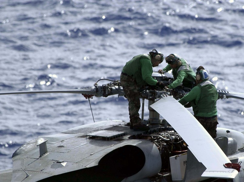 US Navy 041023-N-9228K-014 Aviation Machinist Mates assigned to the Golden Falcons of Helicopter Anti-Submarine Squadron Two (HS-2) check the rotor blades of an SH-60F Seahawk