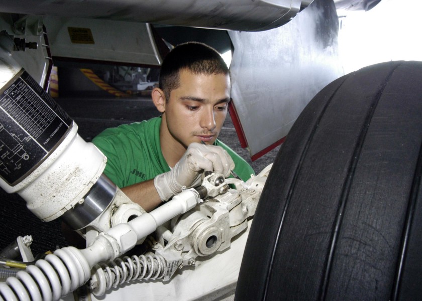 US Navy 041117-N-7816R-012 Aviation Structural Mechanic 3rd Class Jimenez Jorge of Houston, Texas, paints the landing gear assembly on an F-A-18E Super Hornet
