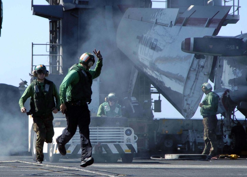 US Navy 041118-N-0057P-008 Flight deck personnel guide a tractor used to help rig a barricade during a runaway plane drill on the flight deck of the Nimitz-class aircraft carrier USS Abraham Lincoln (CVN 72)