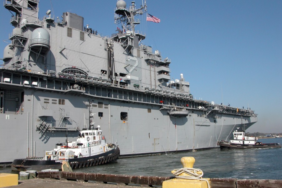 US Navy 050125-N-4397B-004 Tugs boats maneuver the amphibious assault ship USS Saipan (LHA 2) up to the pier at Terminal G of Bayou Casotte East Harbor in the Port of Pascagoula, Miss