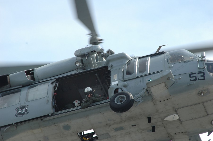 US Navy 050519-N-5781F-087 An air crewman watches cargo being lifted by an MH-60S Knighthawk during a vertical replenishment at sea