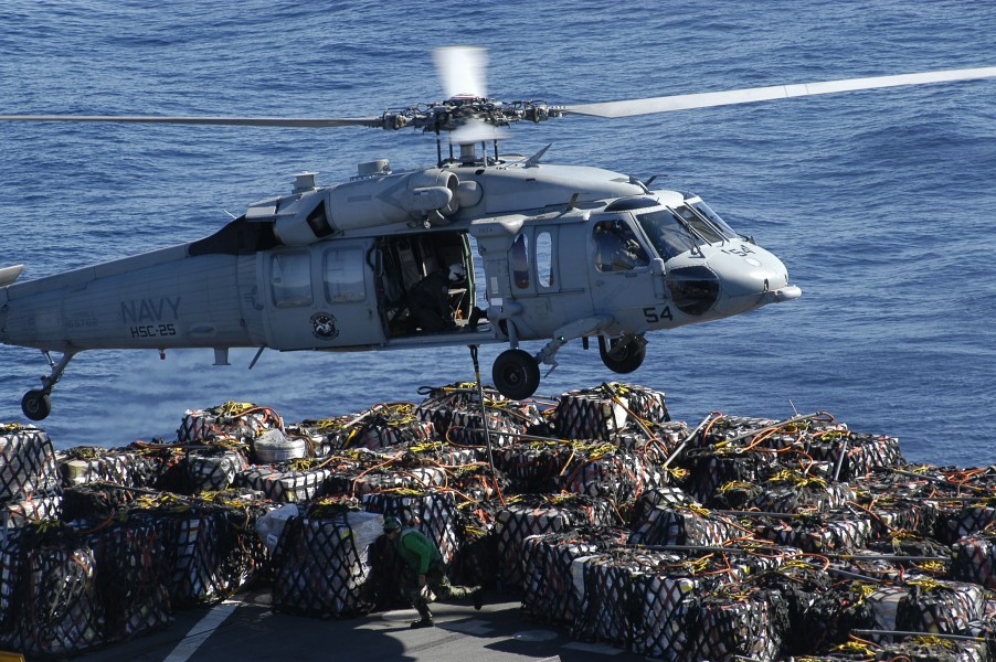 US Navy 050618-N-0167B-129 A Sailor assigned to the Military Sealift Command (MSC) combat stores ship USNS Niagara Falls (T-AFS 3), runs across the flight deck after attaching a cargo pallet to an MH-60S Seahawk