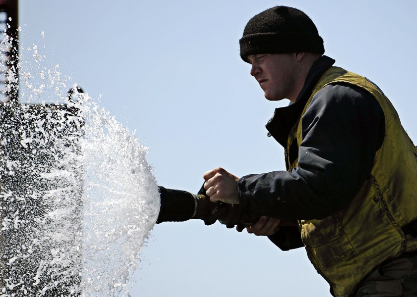 US Navy 050623-N-4166B-050 A Sailor assigned to Air Department slowly opens the vari-nozzle of a fire hose to spray down the flight deck aboard the Nimitz-class aircraft carrier USS Abraham Lincoln (CVN 72)