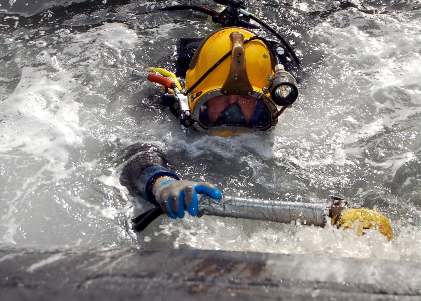 US Navy 051206-N-0879R-005 A U.S. Navy diver uses a scrubber to clean the hull of the Los Angeles-class fast attack submarine USS Key West (SSN 722)