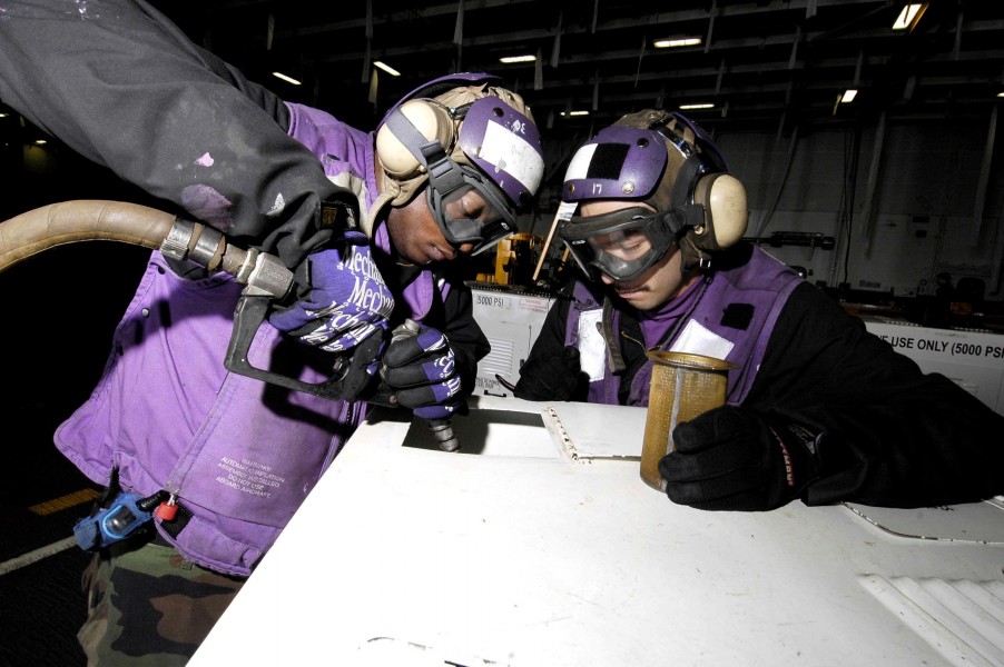 US Navy 060107-N-7981E-039 Airman Recruit Gabriel Salidomendoza and Airman Recruit Gerald Brown fuel support equipment in the hangar bay