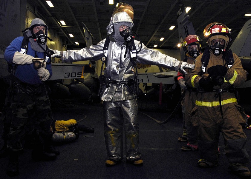 US Navy 060315-N-5837R-036 A scene leader escorts to hose teams into a simulated fire in the hangar bay