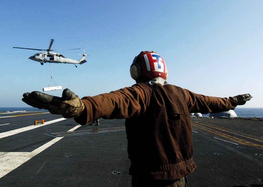 US Navy 060403-N-0499M-093 An Enlisted Landing Signalman gives the hover signal to the pilot