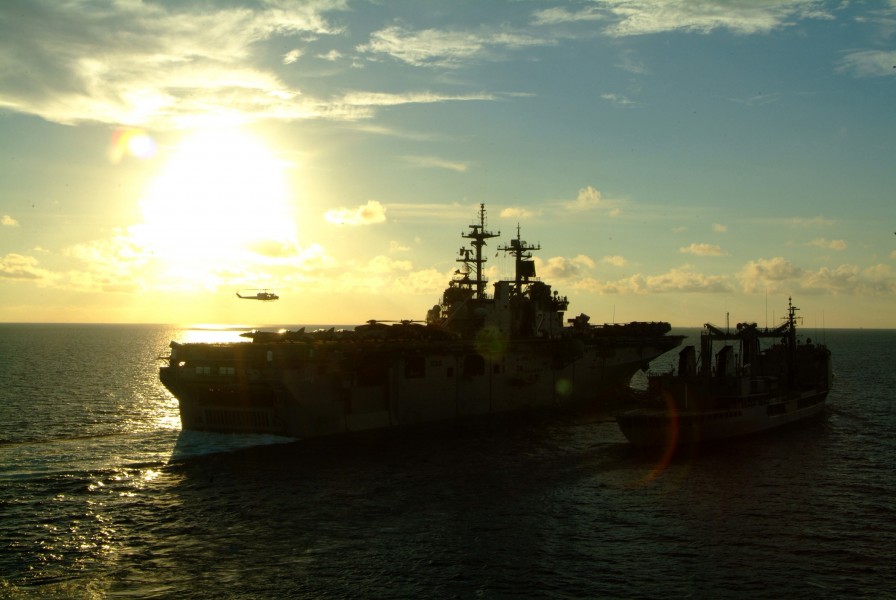US Navy 060530-N-4772B-066 A helicopter hovers over the flight deck of the amphibious assault ship USS Essex (LHD 2) during an underway replenishment