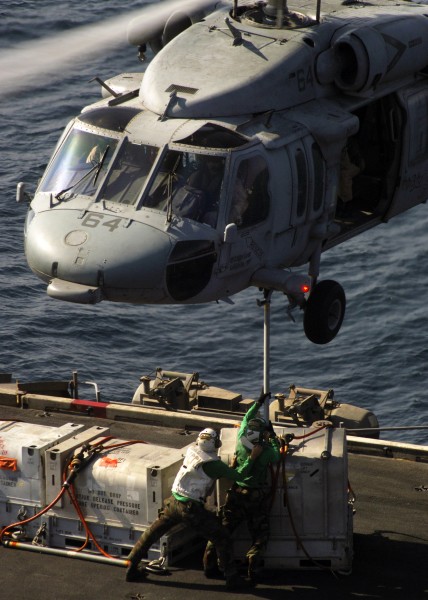 US Navy 071029-N-5928K-007 ailors aboard nuclear-powered aircraft carrier USS Enterprise (CVN 65) attach supplies to the belly of a MH-60S Seahawk