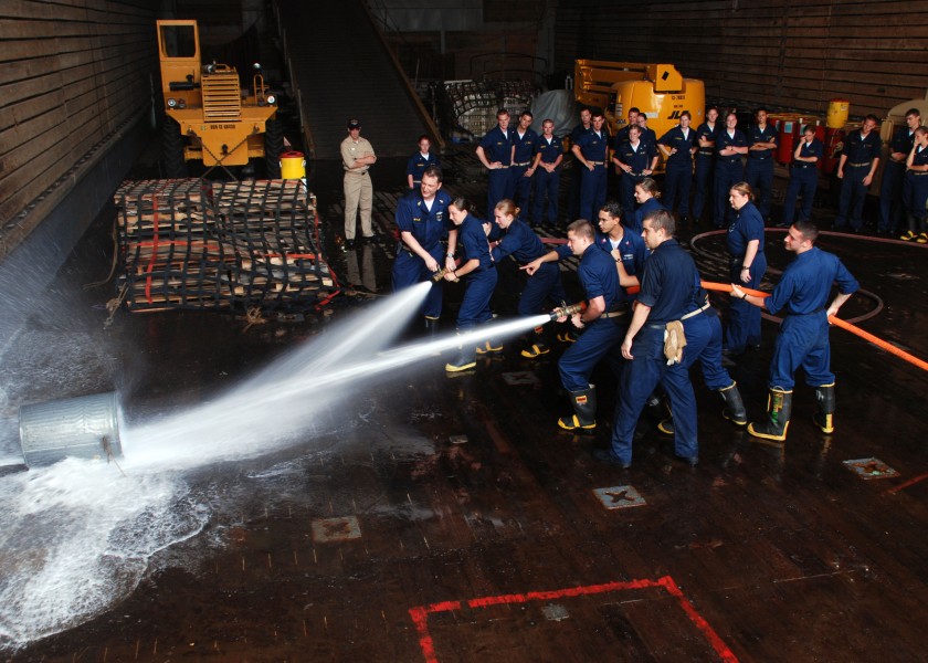 US Navy 080602-N-7987H-040 Midshipmen embarked aboard the amphibious dock landing ship USS Ashland (LSD 48) practice hose handling techniques with Damage Controlmen in the well deck