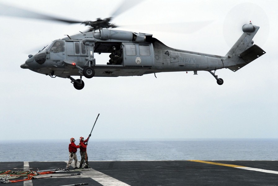 US Navy 080625-N-2610F-084 Flight Deck Gunner Chief Warrant Officer Eric Richmond, left, and Aviation Ordanceman 3rd Christopher Wozniak connect hoisting slings to an MH-60S Seahawk