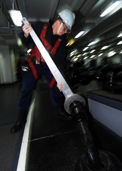 US Navy 090112-N-6538W-056 Boatswain's Mate Seaman Ronald Warner wrenches a riding stopper turnbuckle