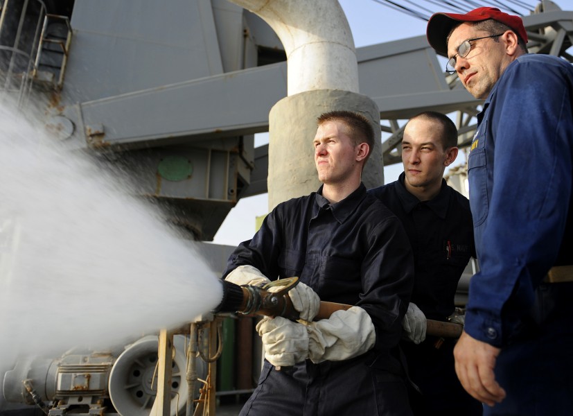 US Navy 090914-N-5345W-263 Chief Damage Controlman Donald Grothe supervises Hull Maintenance Technician 3rd Class John South and Damage Controlman Fireman David Pritchard during a hose-handling training exercise