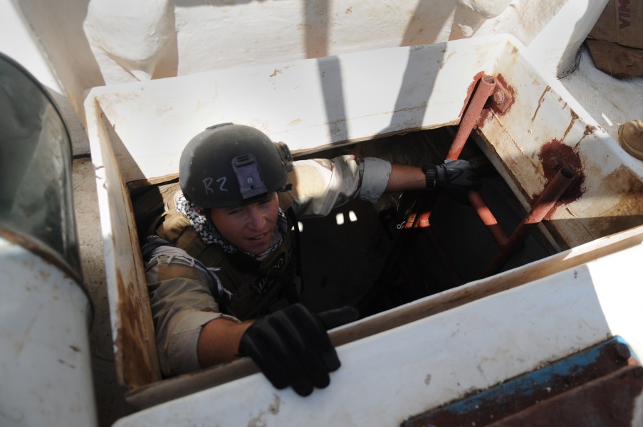 US Navy 091027-N-4154B-077 Machinery Technician 1st Class William Porter climbs out of a hold aboard a fishing vessel