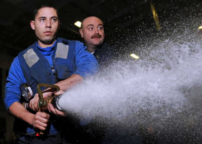 US Navy 100115-N-1261P-017 Aviation Boatswain's Mate (Handling) Freddy Vigilmartinez learns from Chief Damage Controlman Samuel Cavanaugh the proper