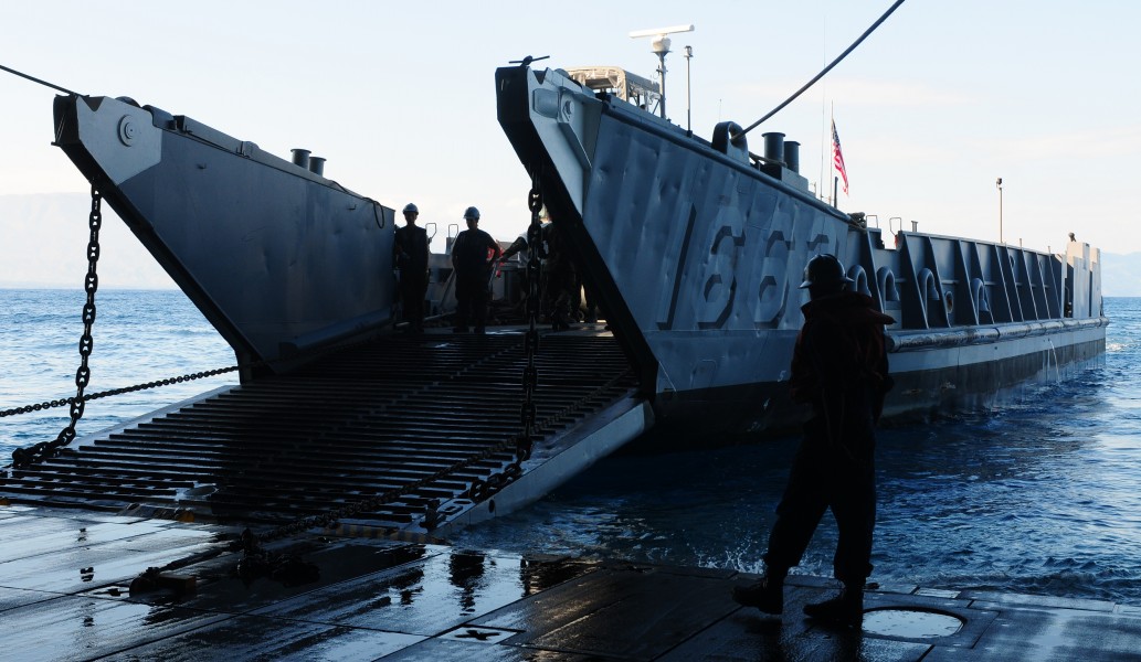 US Navy 100201-N-1831S-052 ilors from Landing Craft Unit (LCU) 1663, assigned to Assault Craft Unit (ACU) 2, load supplies during a stern gate marriage with the amphibious assault ship USS Bataan (LHD 5)