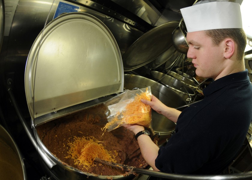 US Navy 100226-N-9435M-023 Culinary Specialist Seaman Garrett Cook prepares refried beans for lunch aboard the aircraft carrier USS Abraham Lincoln (CVN 72)