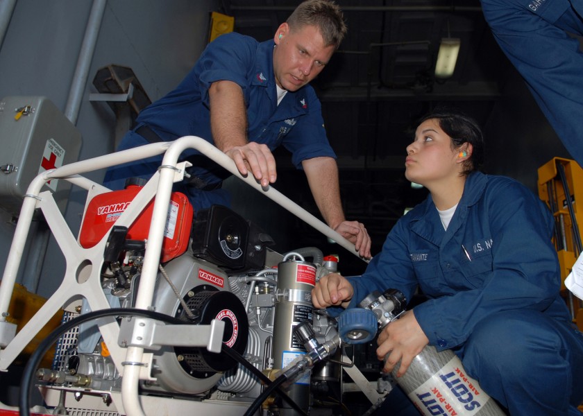 US Navy 100304-N-6692A-041 Damage Controlman 2nd Class Kevin L. Clark instructs Damage Controlman Fireman Recruit Marcela R. Bustamante on charging an oxygen bottle for self-contained breathing apparatus
