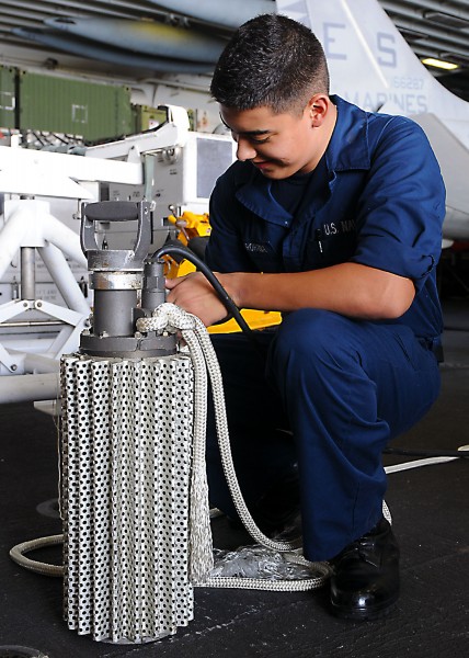 US Navy 101116-N-2908M-009 Damage Controlman Fireman Luis Baezarohana attaches a line to an electrical submersible pump to prepare for a damage con