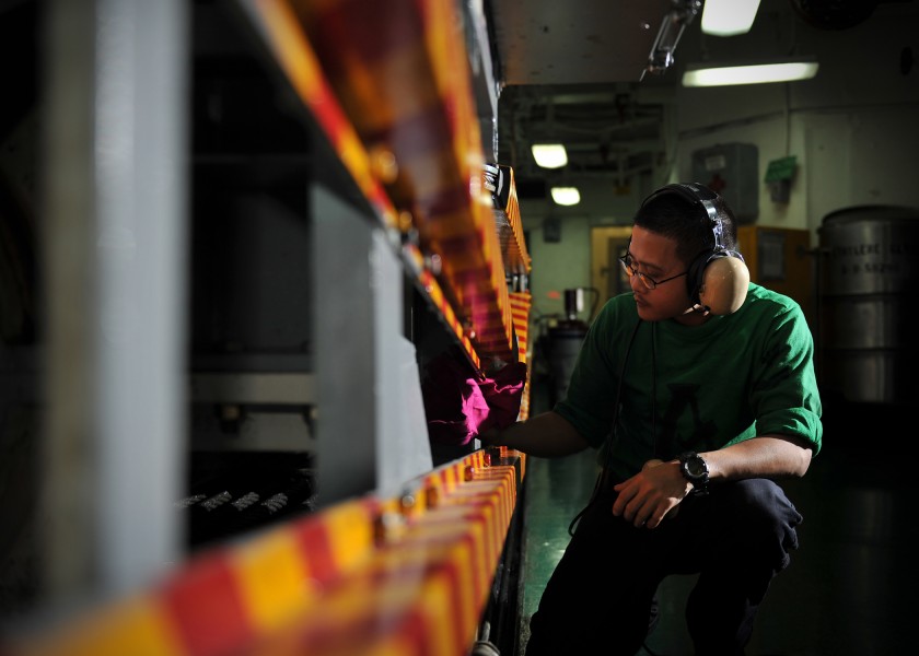 US Navy 110127-N-2937R-036 Aviation Boatswain's Mate (Equipment) 3rd Class Manata Marlon cleans an arresting engine gear catapult