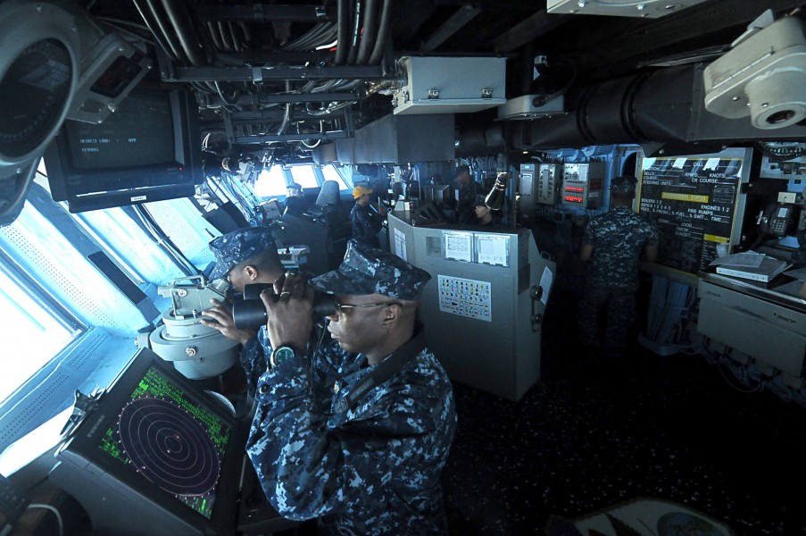US Navy 110313-N-4743B-005 Sailors on the bridge of the forward-deployed amphibious assault ship USS Essex (LHD 2) navigate the ship to the coast o