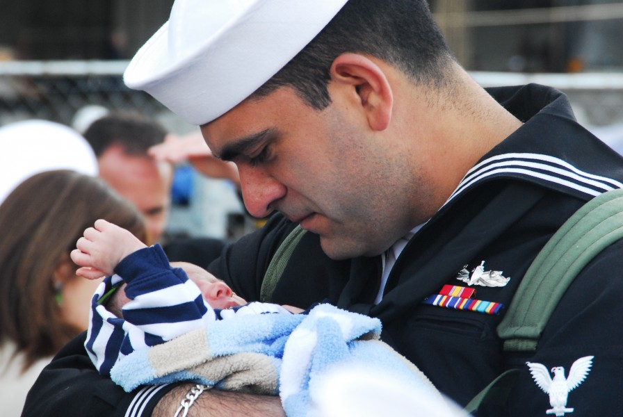 US Navy 110324-N-QW737-008 A Sailor hugs his baby upon arriving home aboard the aircraft carrier USS Abraham Lincoln (CVN 72)