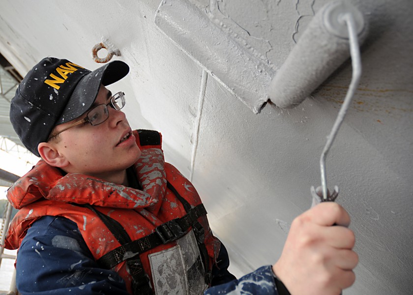 US Navy 110426-N-2218M-004 Seaman Jamie Corbin, from Austin, Minn., paints the hull of the aircraft carrier USS Abraham Lincoln (CVN 72)