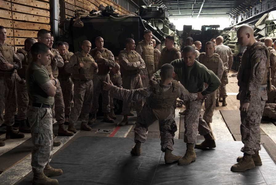 US Navy 110426-N-QP268-036 Cpl. Derek Black demonstrates a proper leg-sweeping movement to fellow Marines aboard USS Whidbey Island (LSD 41)