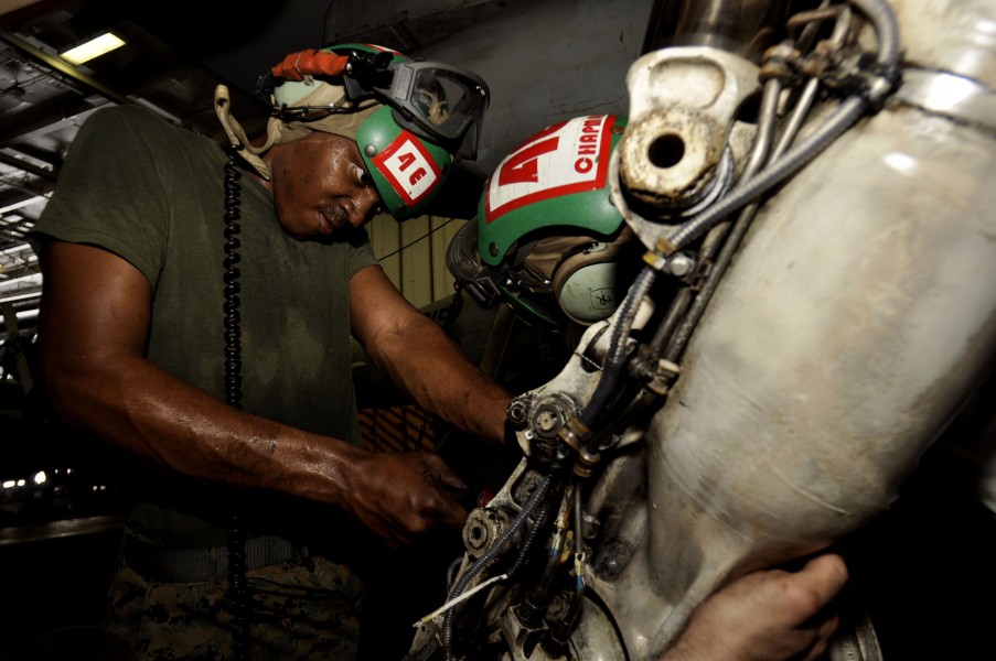 US Navy 110718-N-ZZ999-015 Sgt. Anthony Rumlin, from Tampa, Fla., removes a prox switch from the landing gear assembly of an F-A-18 Hornet aboard t
