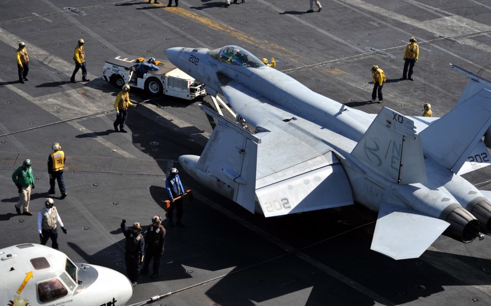 US Navy 111006-N-YB753-002 Sailors tow an F-A-18E Super Hornet assigned to the Kestrels of Strike Fighter Squadron (VFA) 137 on the flight deck of 
