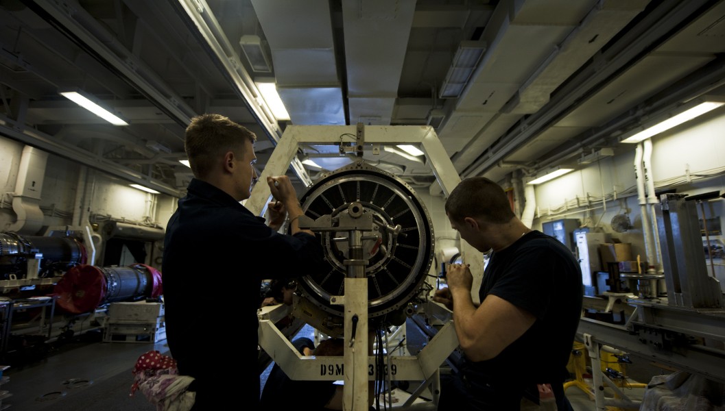 US Navy 111008-N-TU221-386 Aviation Machinist's Mate Airman Jason Nitz and Airman Stefhan Spaulding tighten screws on the frame of a jet engine ins