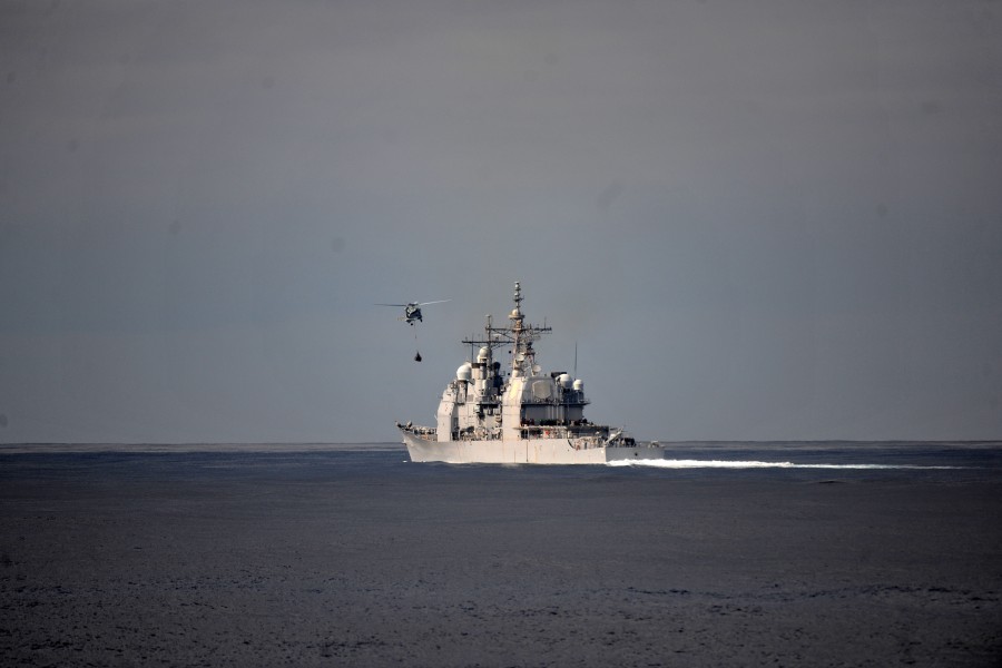 US Navy 111129-N-YZ751-198 A helicopter approaches a guided-missile cruiser
