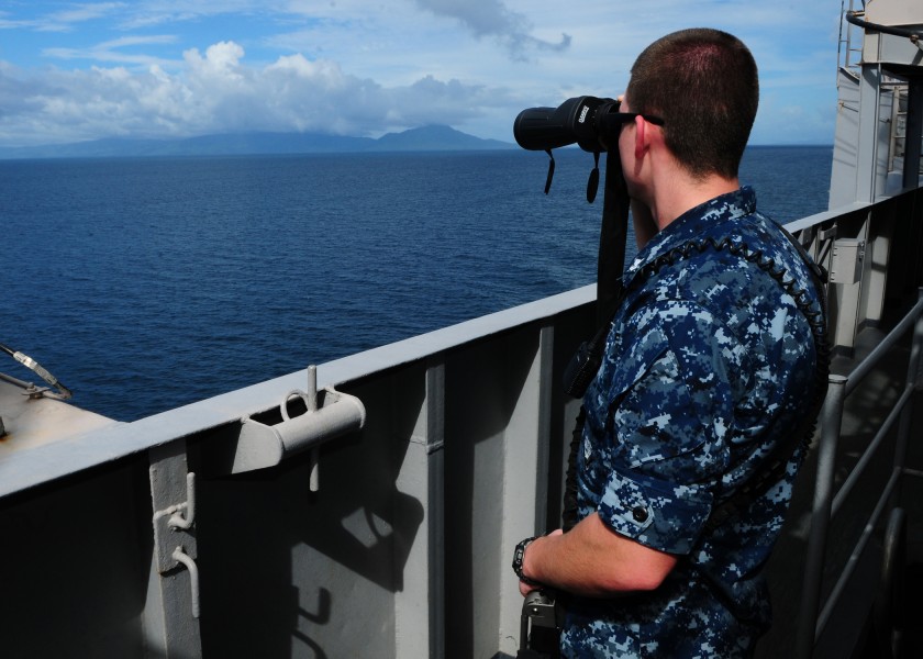 US Navy 120101-N-SK590-031 Engineman 2nd Class Angel Fix looks at the coastline of an island in the Philippines from the Nimitz-class aircraft carr