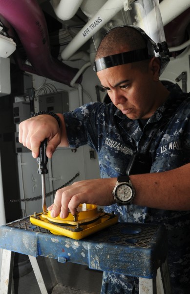 US Navy 120113-N-NB694-016 Aviation Ordnanceman Airman Moises Gonzalez replaces light bulbs in battle lanterns aboard the Nimitz-class aircraft ca