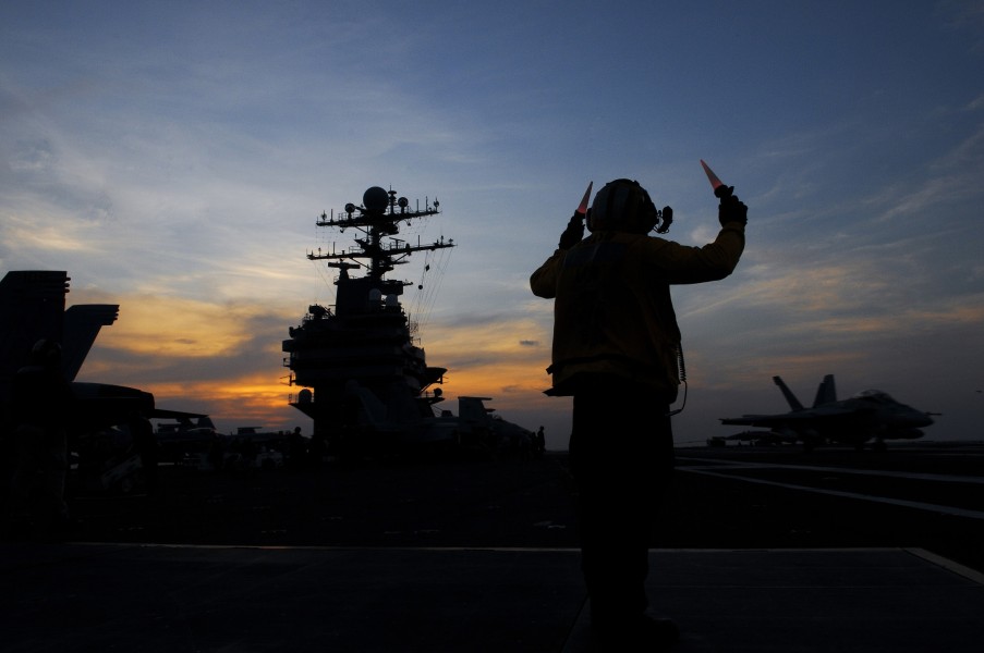 US Navy 120117-N-JN612-333 Aviation Boatswain's Mate (Handling) Airman Manuel Rogers directs an F-A-18C Hornet during recovery operations on the fl