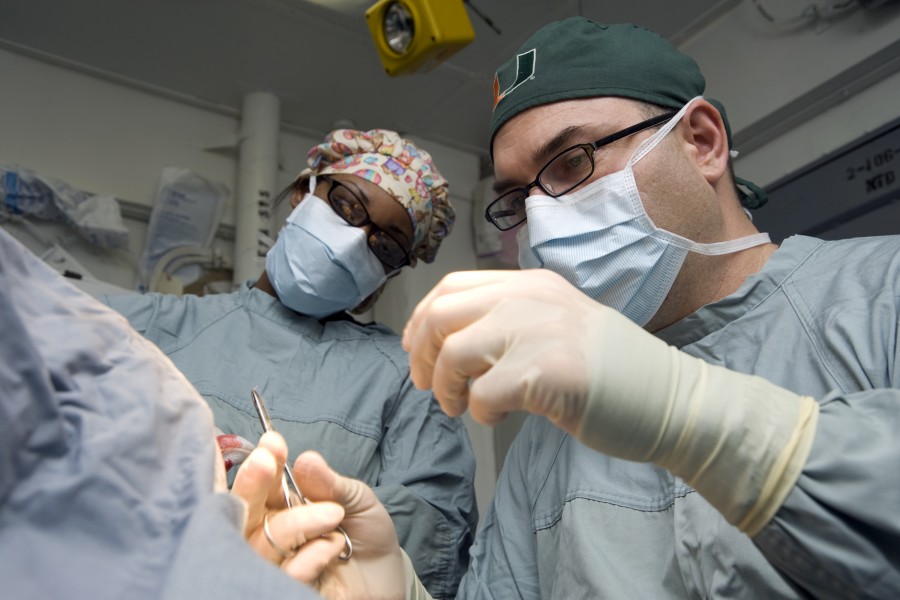 US Navy 120120-N-JN664-004 Lt. Cmdr. Howard Pryor, a Navy doctor, stitches an incision while Hospital Corpsman 3rd Class Destiny Dansby observes in