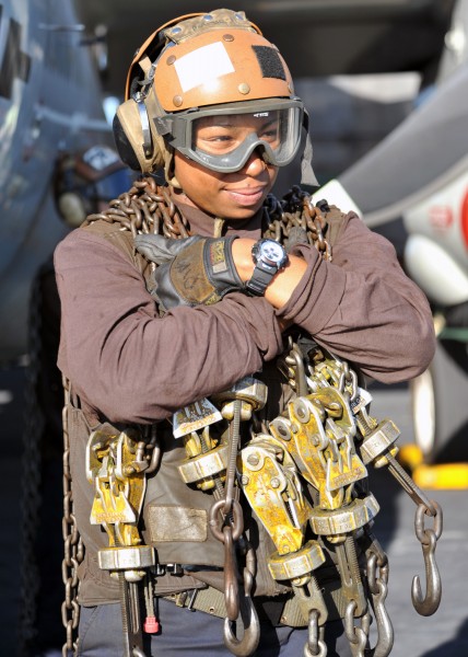 US Navy 120120-N-YB753-016 A plane captain carries tie-down chains across the flight deck of the Nimitz-class aircraft carrier USS Abraham Lincoln 