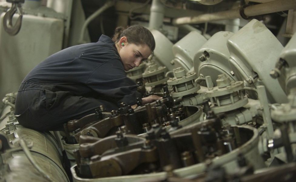 US Navy 120124-N-PB383-327 Engineman Fireman Recruit Megan Cotrell conducts maintenance on an engine in one of the main spaces aboard the amphibiou